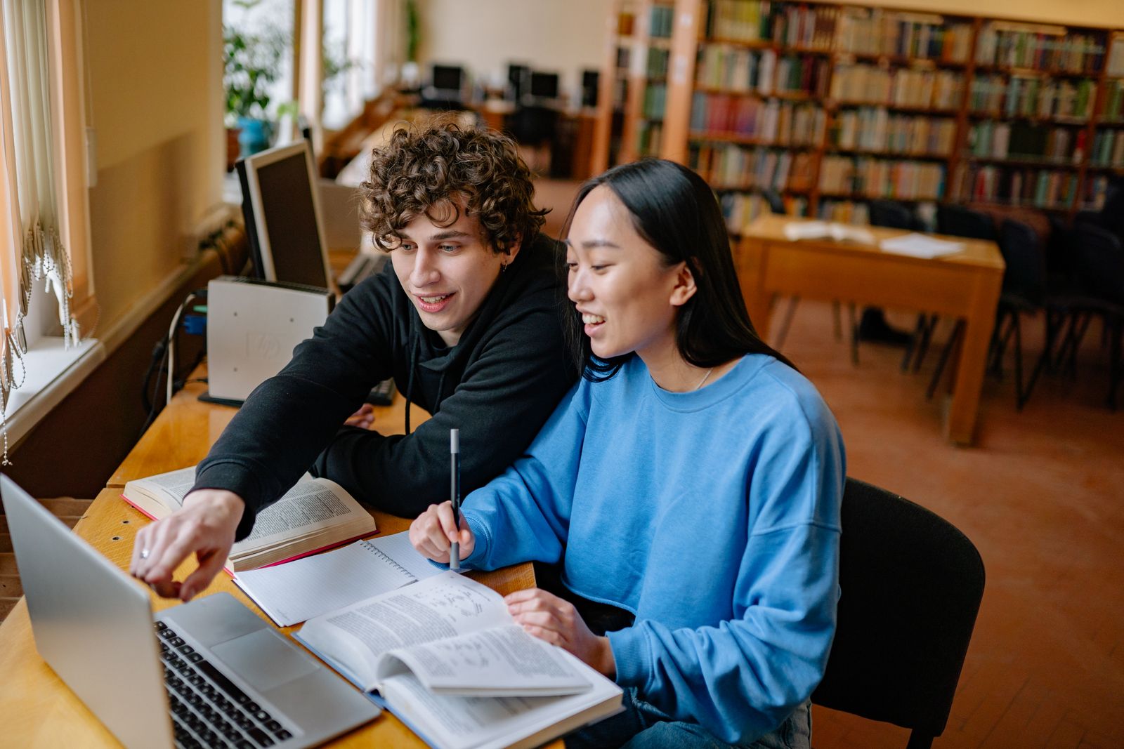 Students studying together with laptops and books