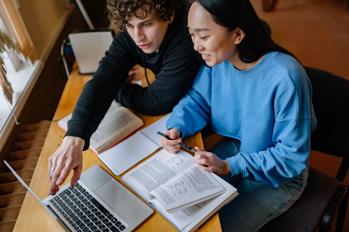 Two students studying together and looking at a laptop screen