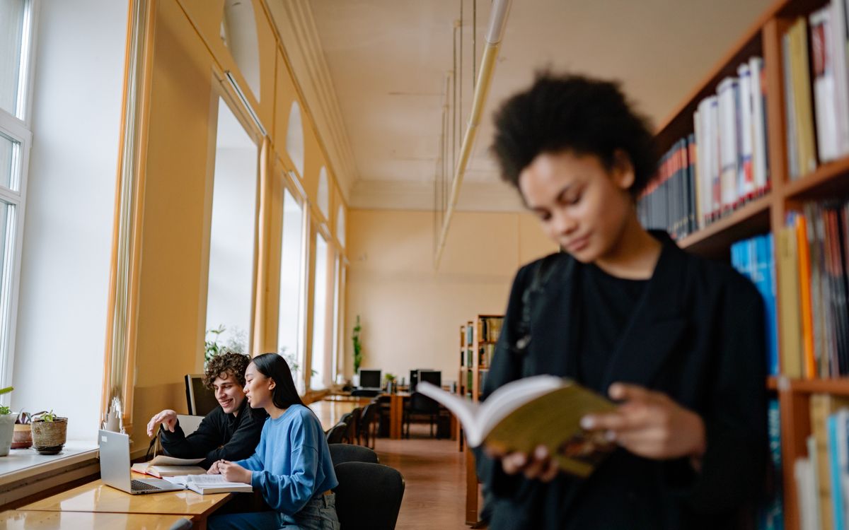 Student preparing university application documents in a library