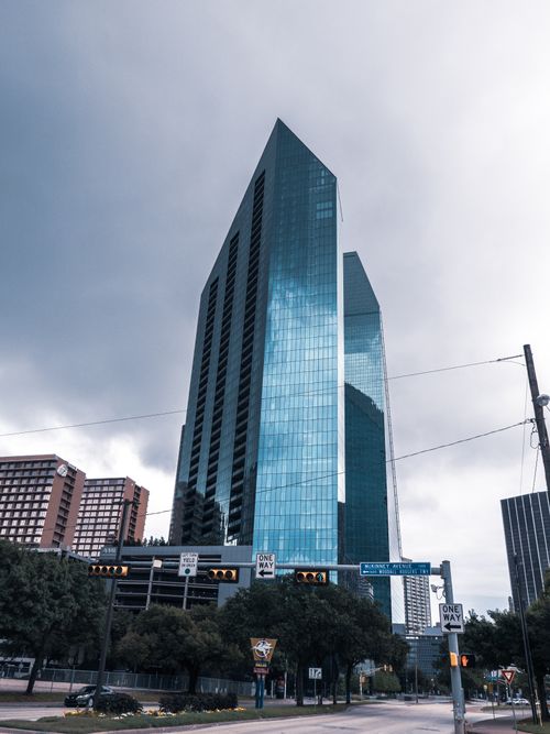 Free Modern glass skyscraper towers over city streets in an urban setting, showcasing sleek architecture. Stock Photo