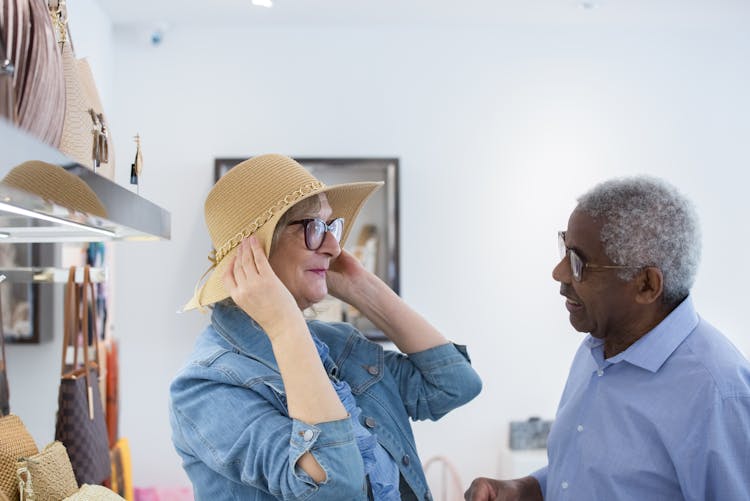 An Elderly Woman Fitting A Brown Hat