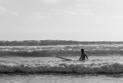 Black and White Photography of a Woman Kayaking in the Sea