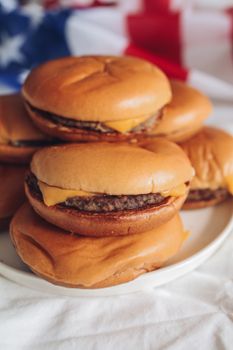 Close-up of delicious cheeseburgers with USA flag background, perfect for July 4th celebrations.