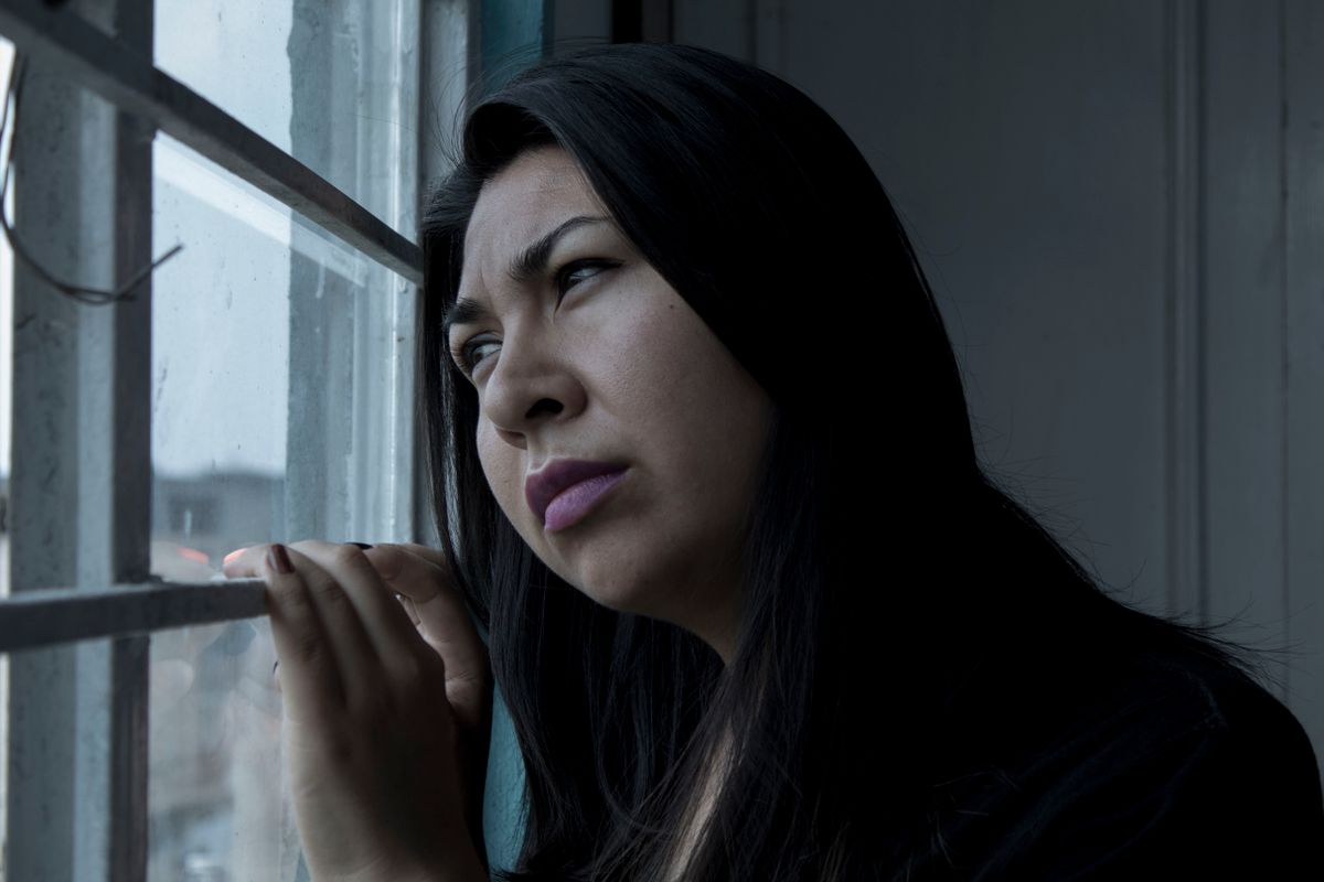 A person sitting quietly at home, thinking things over