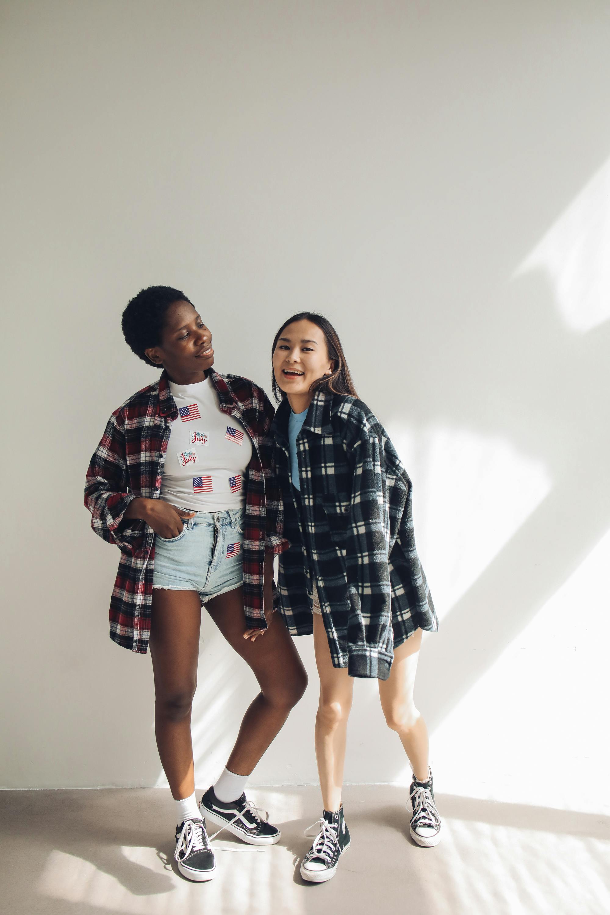 women wearing plaid button up shirts and black sneakers