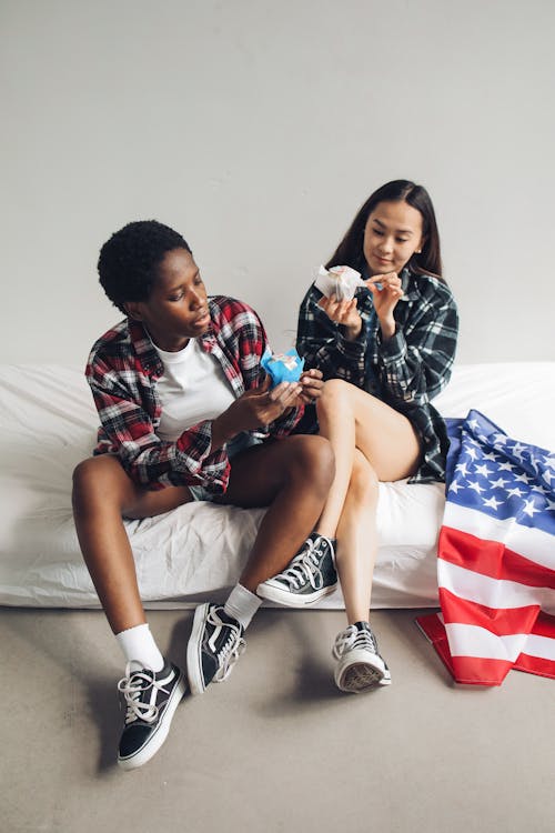 Women Sitting on the Bed Holding Cupcakes