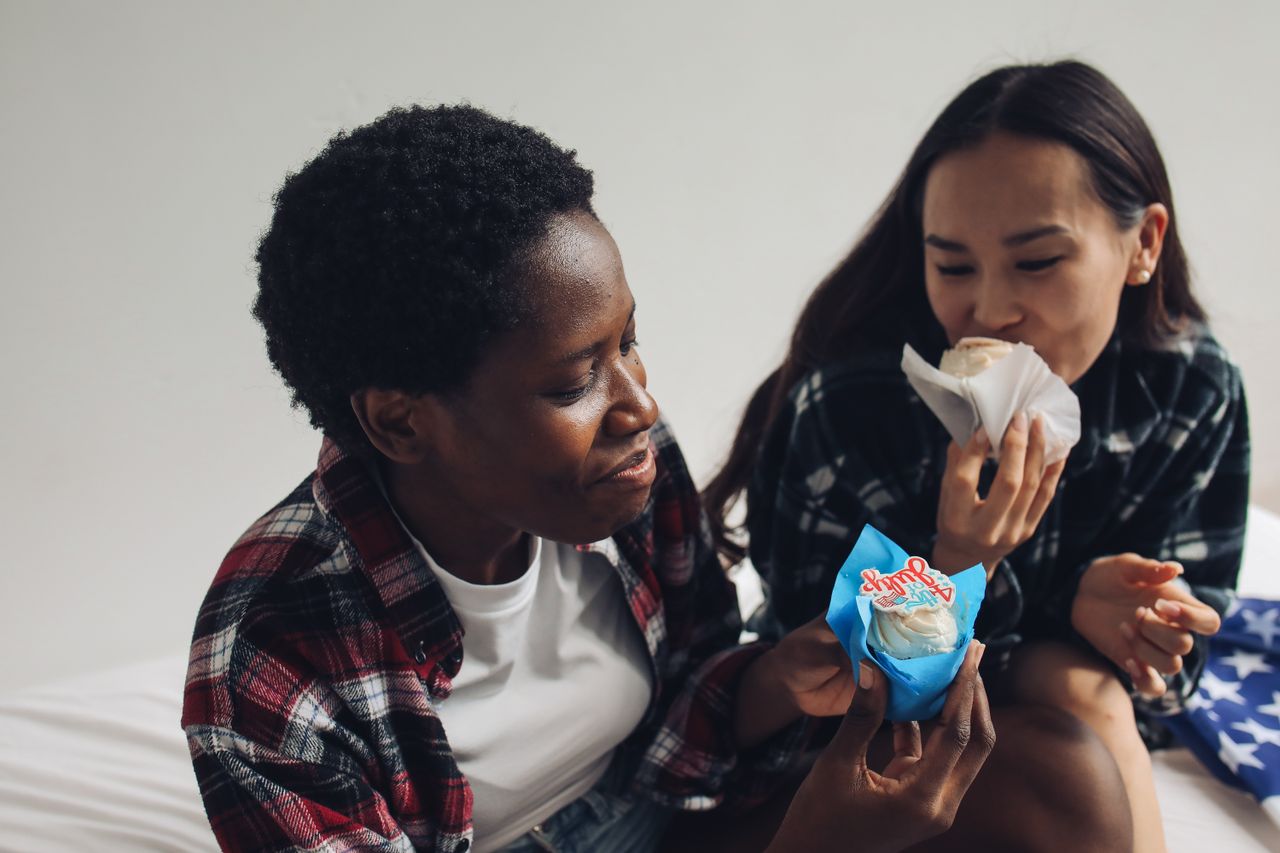 two women laughing and enjoying cupcakes decorated for the 4th of july