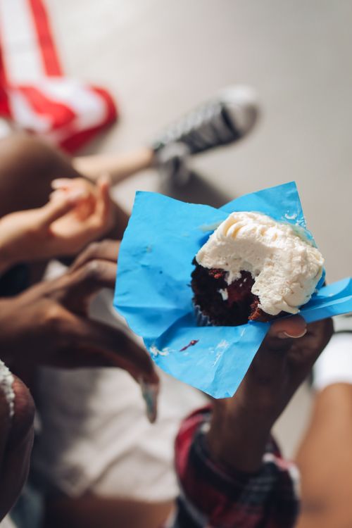 Free Close-up of a red velvet cupcake with creamy icing, perfect for dessert lovers. Stock Photo