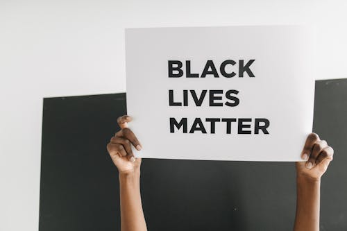 Hands Holding a Poster with Black Lives Matter Text