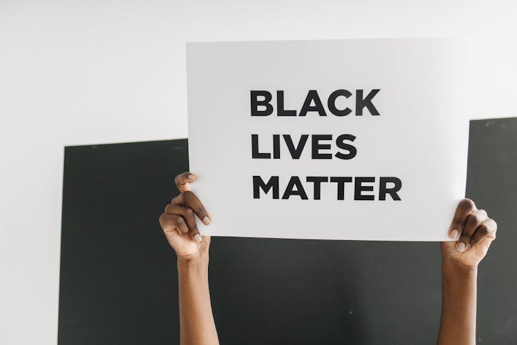 Hands Holding A Poster With Black Lives Matter Text