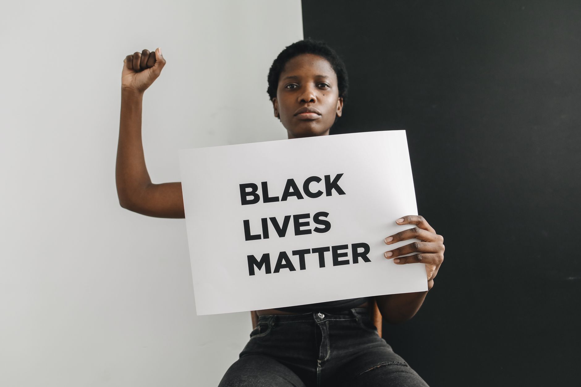 African American woman holding a Black Lives Matter sign, symbolizing empowerment and protest.