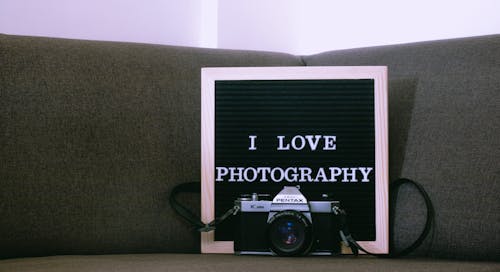 Close-Up Shot of Asahi Pentax Camera Near a Wooden Frame