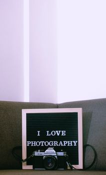 A classic Asahi Pentax camera displayed with a motivational photography sign in a cozy setting.