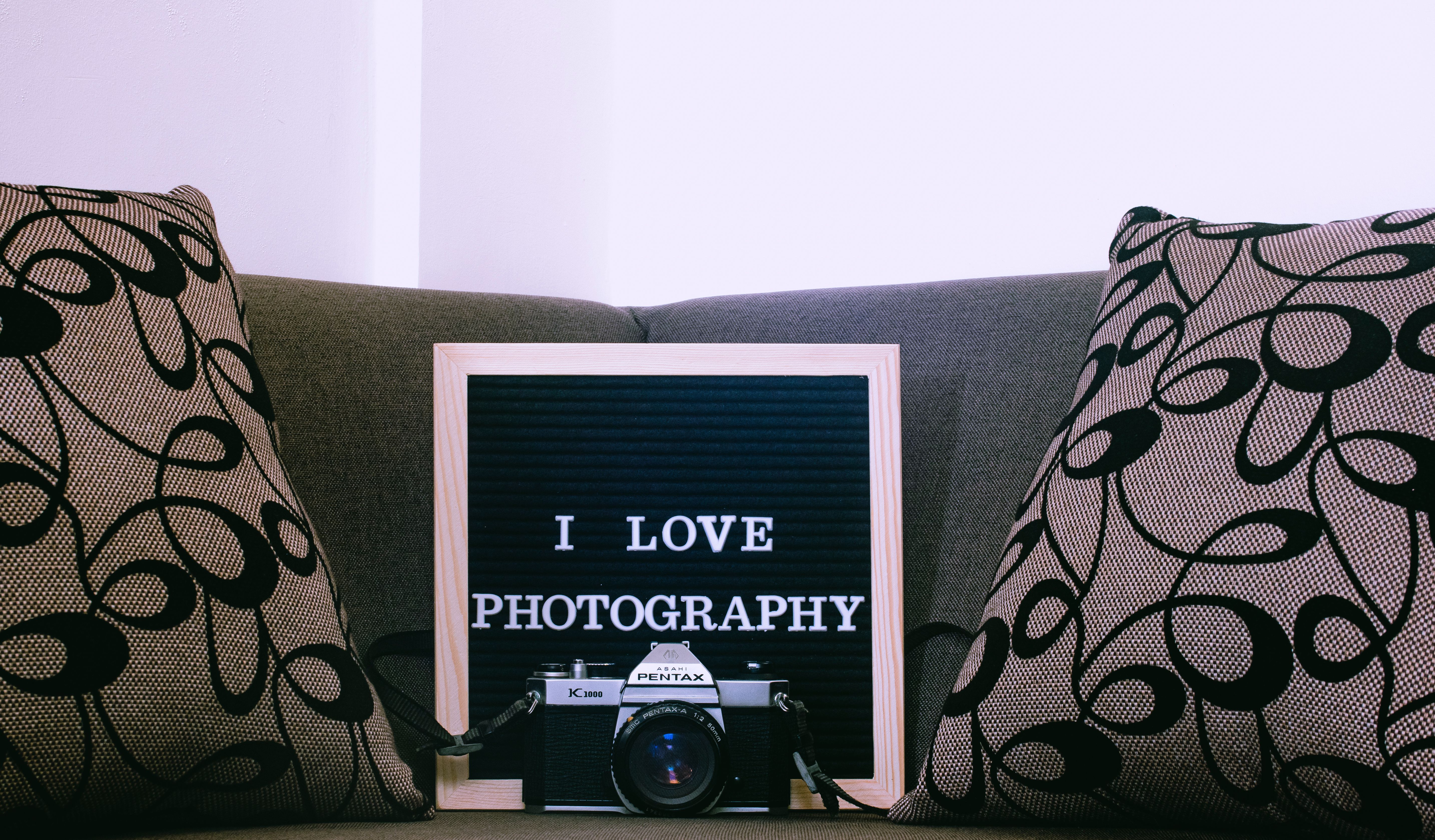 Retro photography setup with a vintage Pentax camera and an inspiring photography quote on a board.