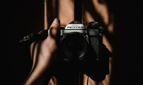 Free Close-up of a person holding a vintage Asahi Pentax camera in dramatic lighting. Stock Photo