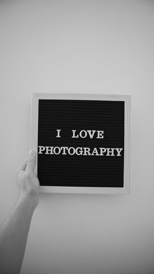 Free Close-Up Shot of Person Holding a Wooden Frame With I Love Photography Text Stock Photo