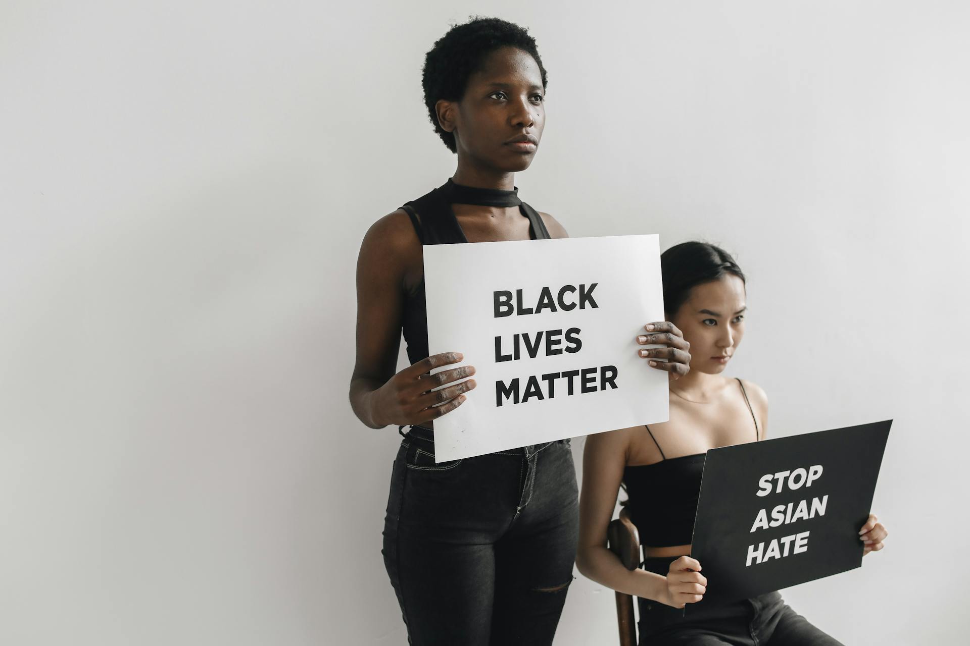 Two Women Holding Signages