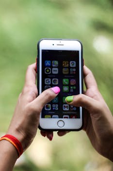 Close-up of a person holding a smartphone displaying various applications in Patna, India.