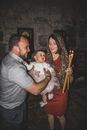 A Man in Gray Polo Getting the Baby from the Woman Holding Lighted Candles