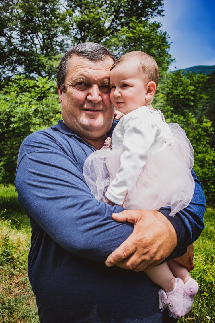 Portrait Of A Grandfather Holding A Baby