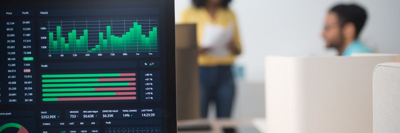 Modern office with financial trading screens and a diverse team discussing strategies.
