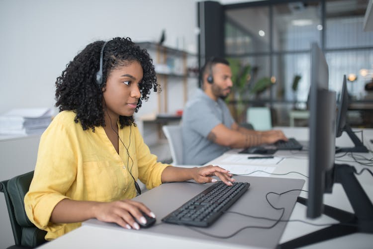 Woman In Yellow Dress Shirt Using Computer