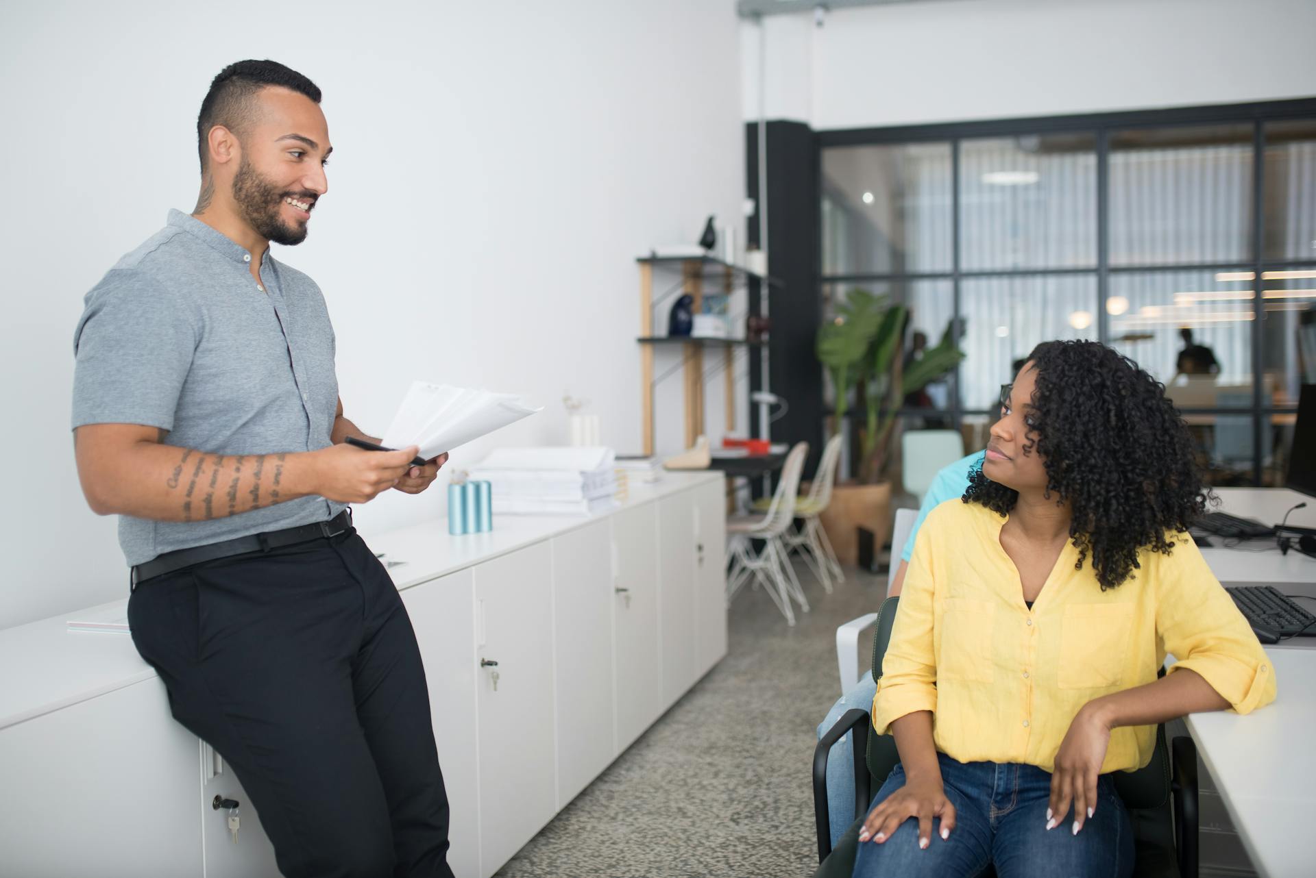 Two office workers engaged in a friendly discussion fostering teamwork and collaboration.