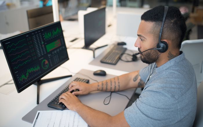 A trader studying multiple screens of stock charts, representing a hedge fund positioning against chip stocks.