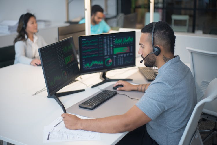 Man In Gray Shirt Working On A Desktop Computers