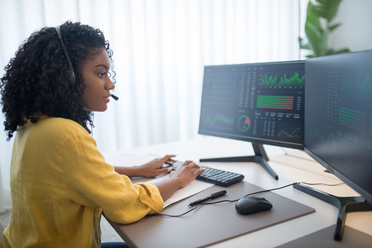 Woman In Yellow Long Sleeve Shirt Looking At Computer Data 