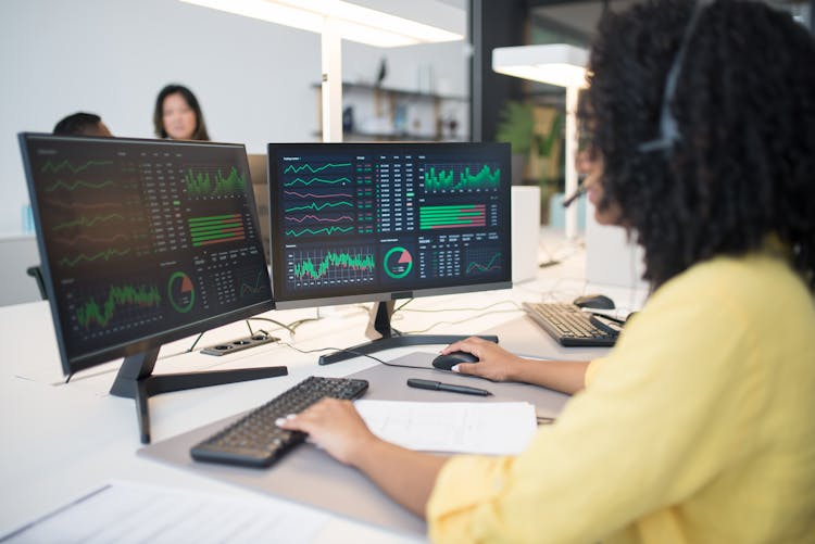 Woman In Yellow Long Sleeve Shirt Looking At Computer Data