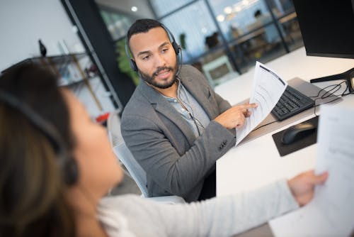 Man Holding a Document Discussing with His Colleague