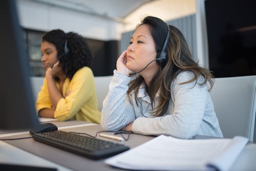 Women in Headsets Sitting at Desk