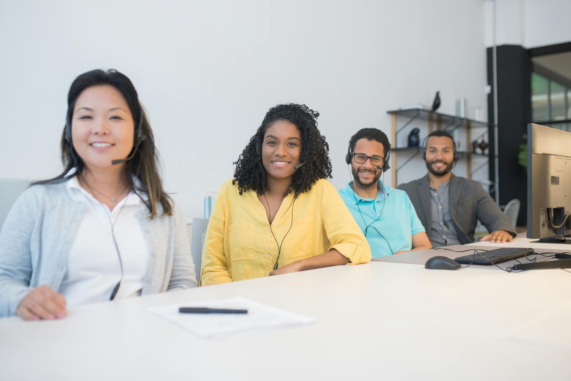 Smiling team with headsets working together in a modern office environment.