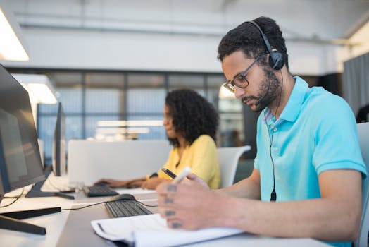 Office employees engaged in productive work at computer stations, enhancing customer service support.