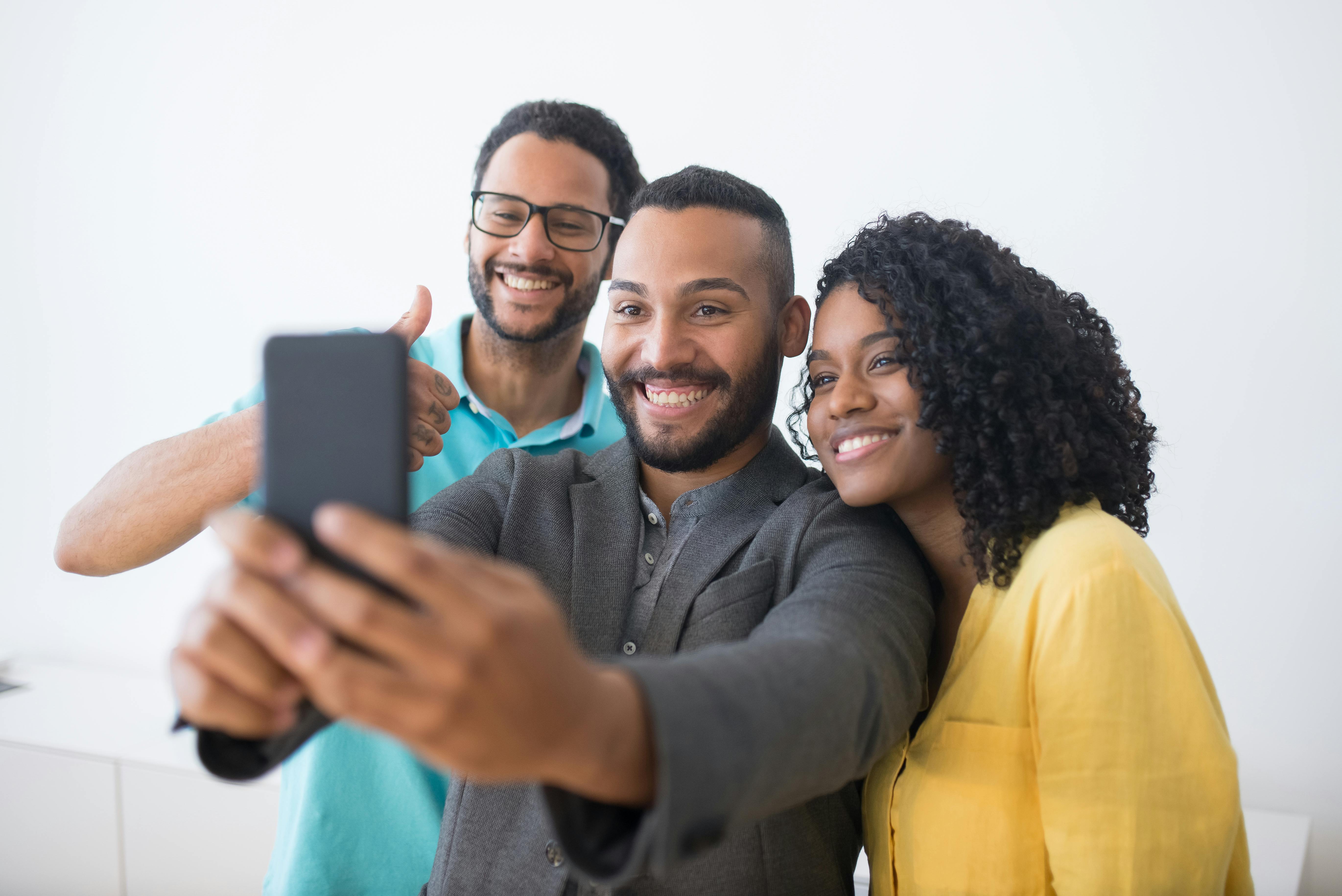 men and woman taking a group selfie