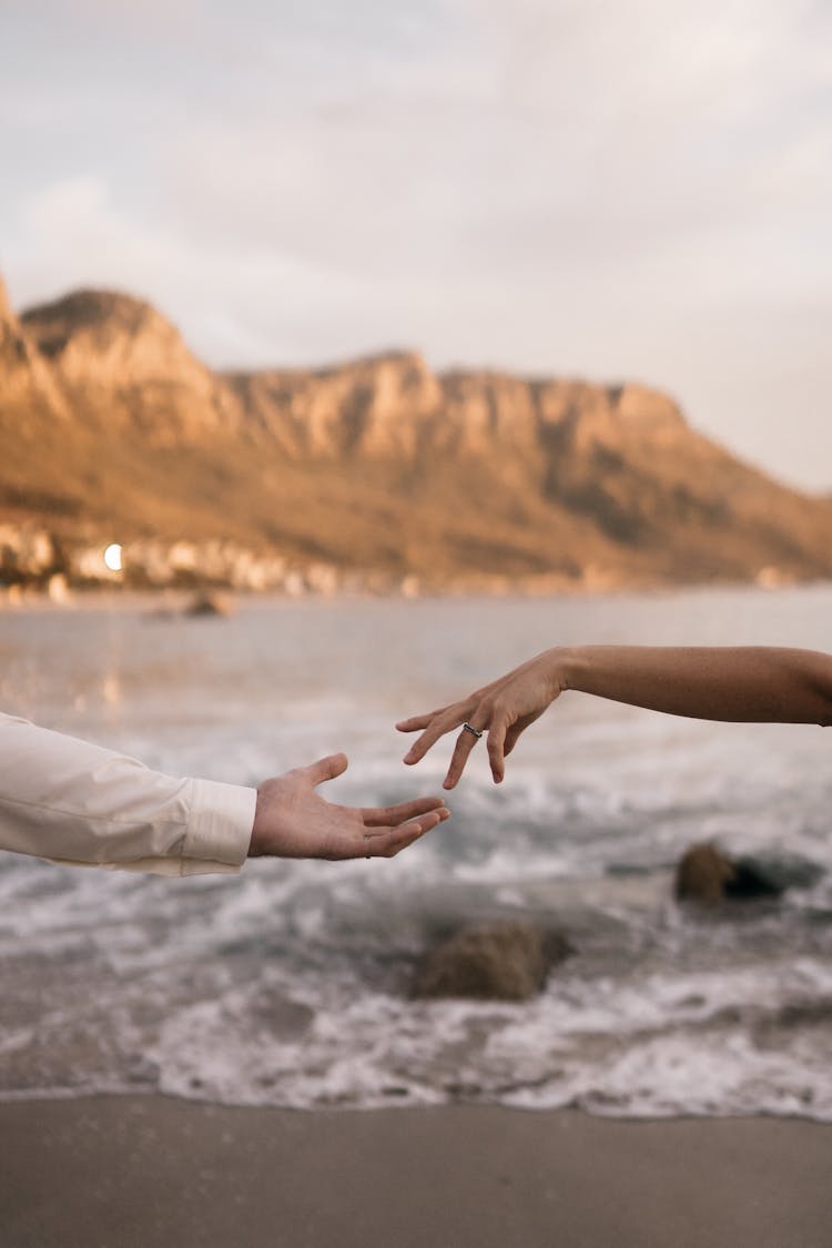 Outstretched Hands Of A Couple On The Beach