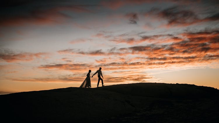 Couple Walking On Top Of A Hill