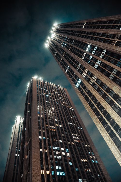 Free Illuminate city skyscrapers captured from a low angle shot, showcasing modern architecture at night. Stock Photo