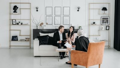 Tres adultos en una discusión profesional en una sala elegante, sobre heredar deudas padre Chile