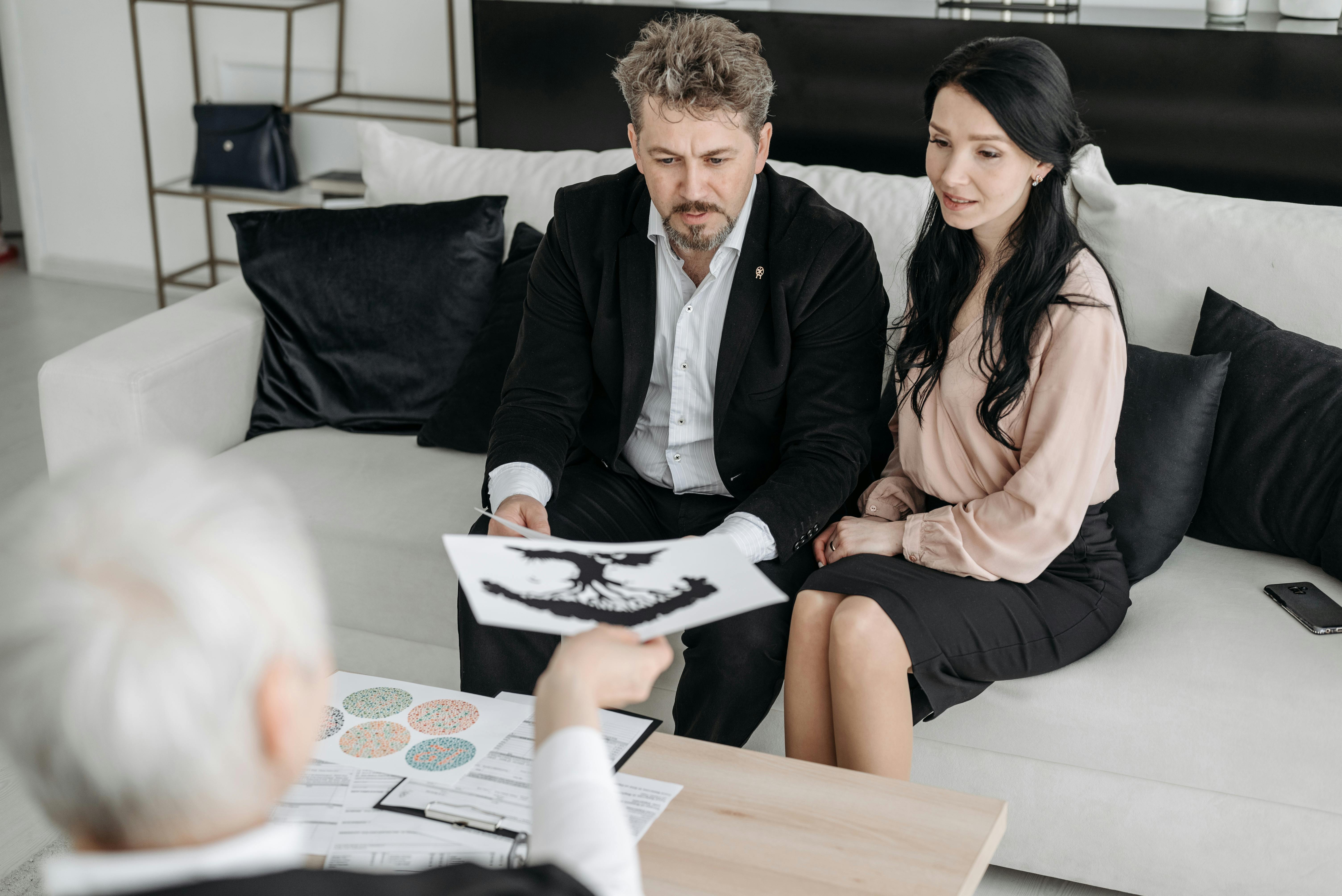 A couple consulting with a professional advisor indoors, focused on documents.