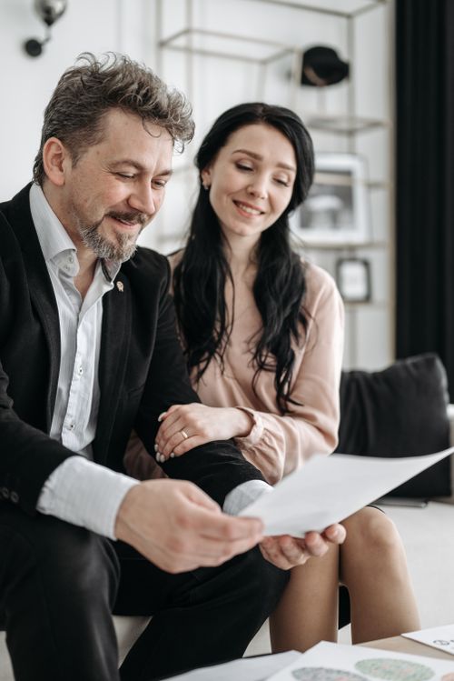 Free Smiling couple reviewing important documents indoors, capturing a happy moment. Stock Photo