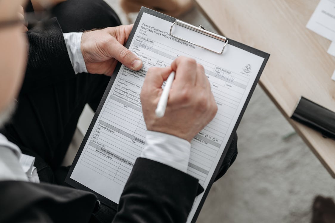 a man writing names of beneficiaries on his trust documents