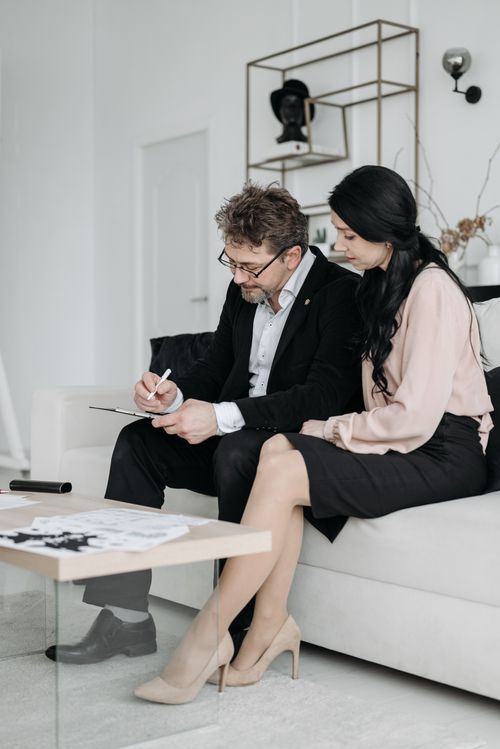 Free A business man and woman signing documents in a modern home interior. Stock Photo