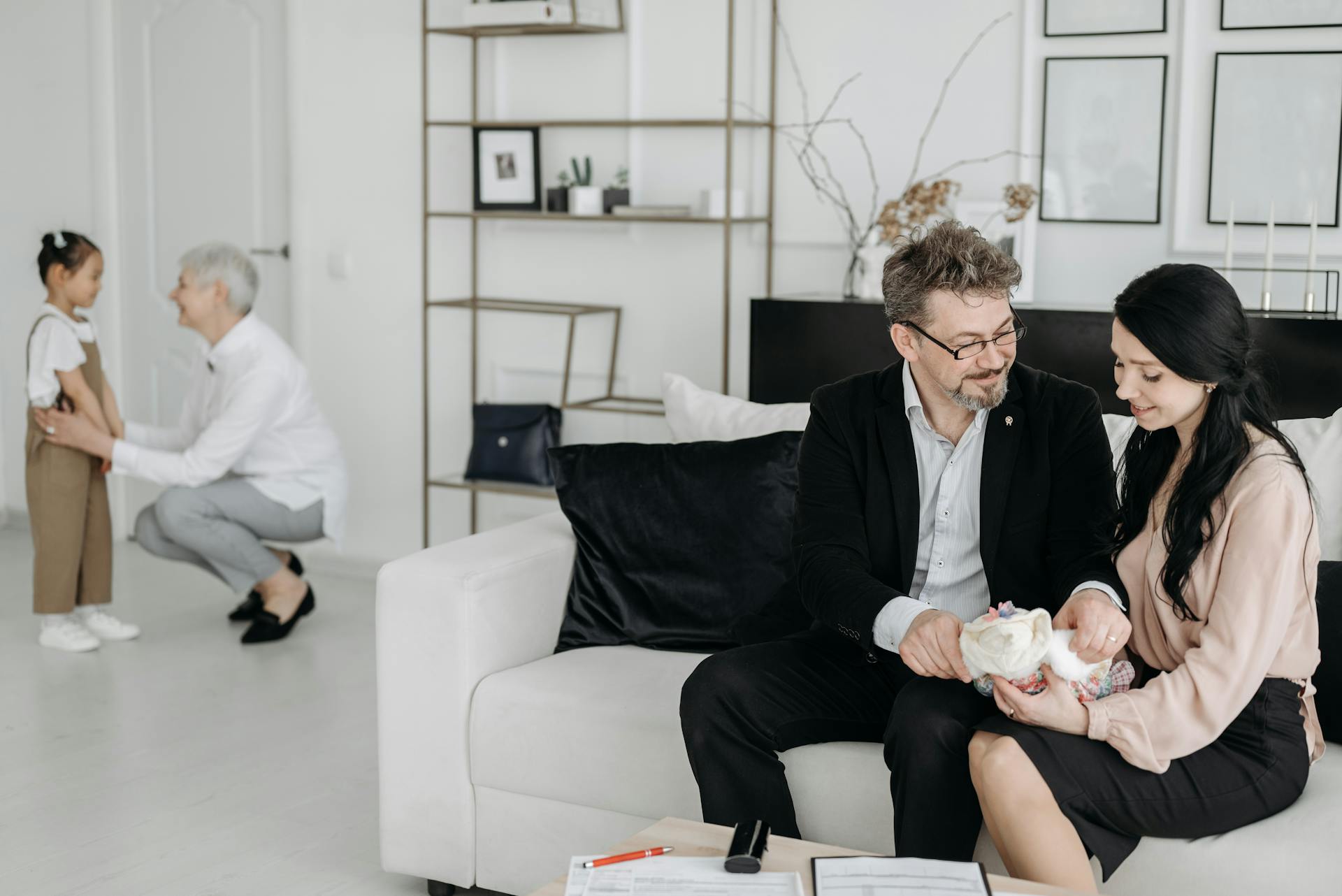 Social Worker Talking to a Child and Waiting Adoptive Parents