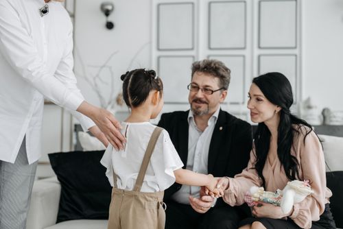 Free A touching moment between prospective parents and a child at an adoption center indoors. Stock Photo