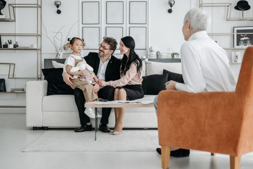 Free A family meets with a social worker in a cozy living room, discussing adoption details. Stock Photo