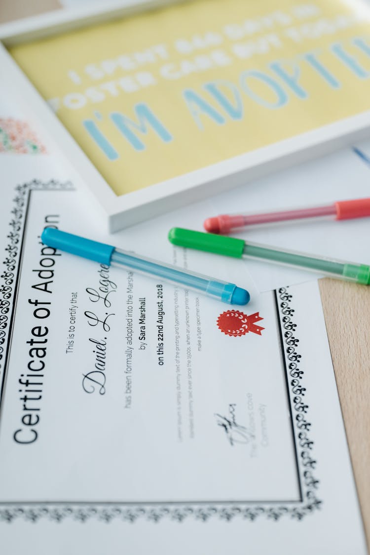 Certificate Of Adoption On Brown Wooden Table