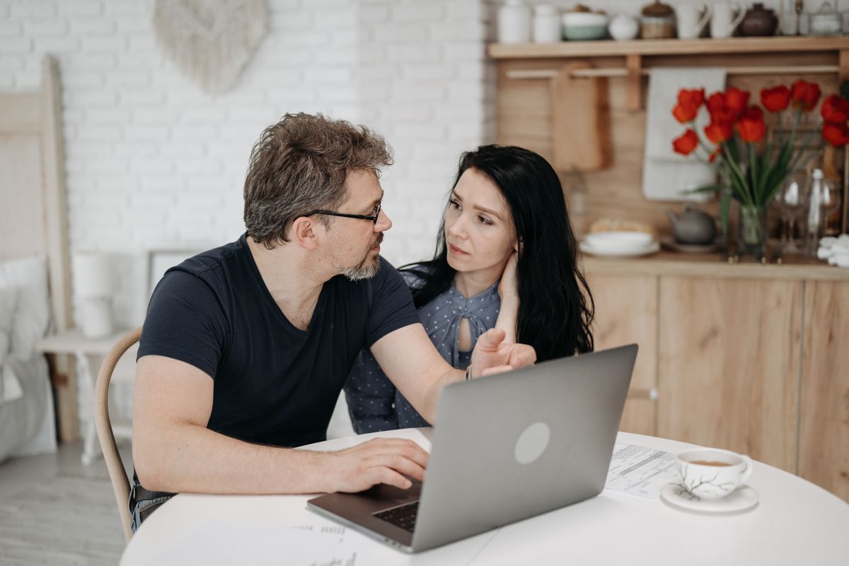Couple at home comparing hospital options and estimates on a laptop before deciding to travel