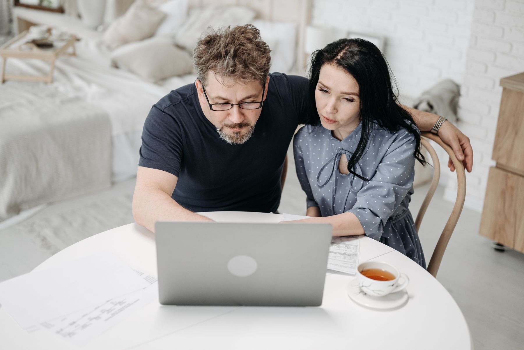 Middle-aged couple working together at home with a laptop